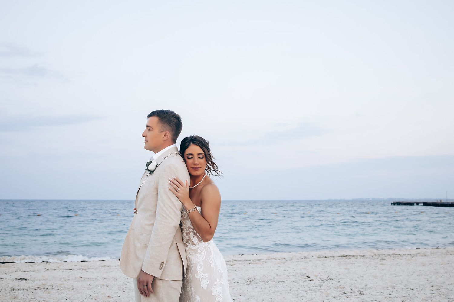 Seaside wedding portraits with waves and beach in the background.