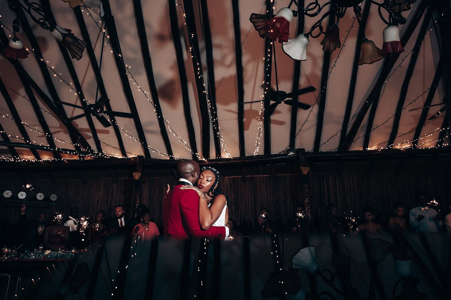 Rustic barn wedding venue decorated with twinkling lights and wooden beams creating a magical atmosphere.