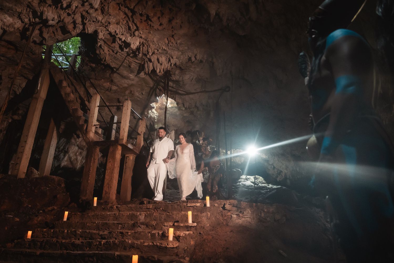 Atmospheric nighttime wedding ceremony with candles illuminating a rustic outdoor setting.