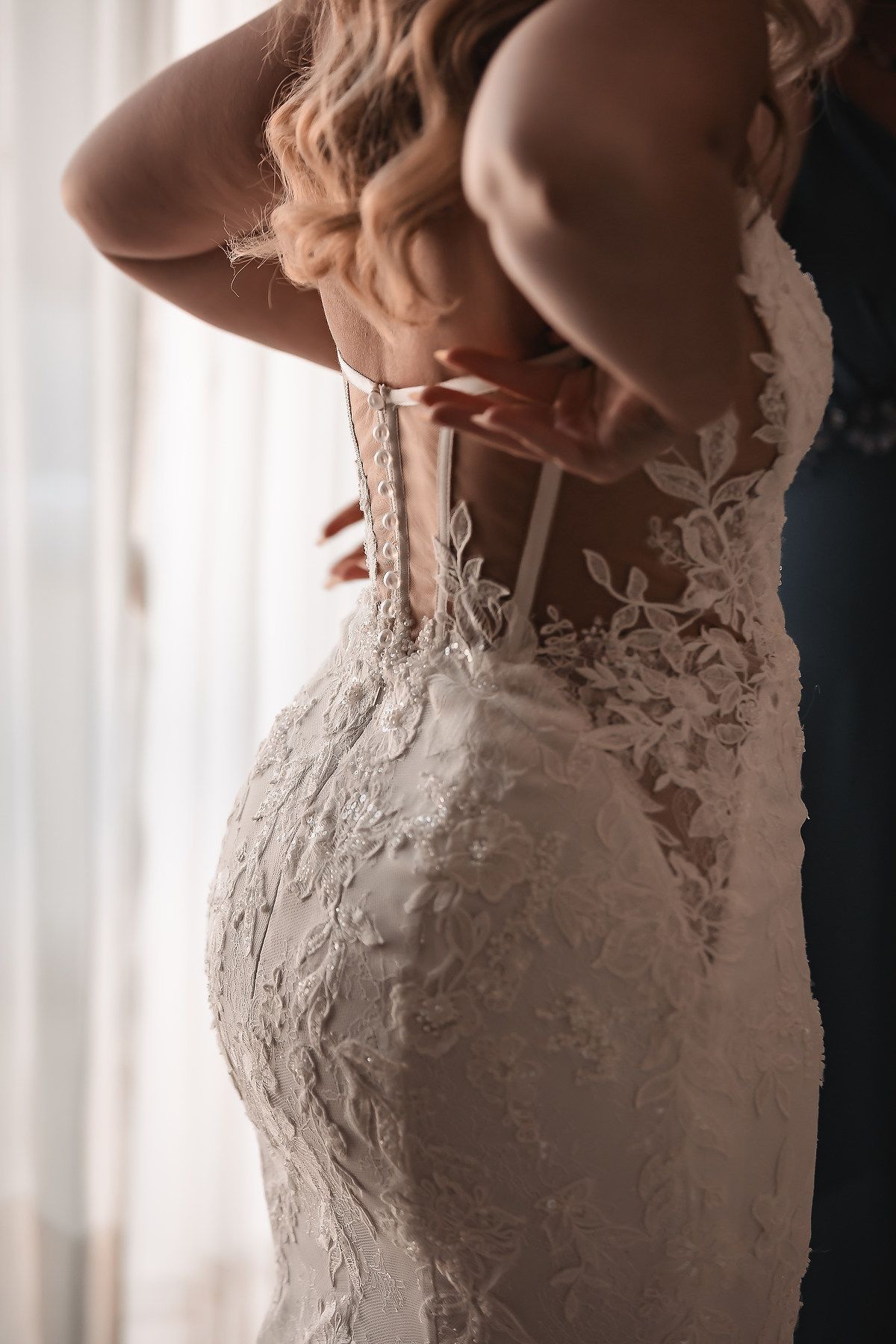Intricate lace detailing on the back of an elegant white wedding gown.
