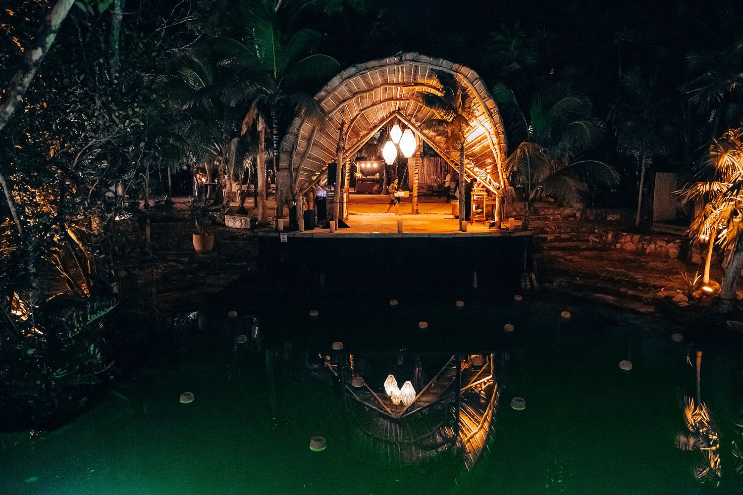 Outdoor nighttime venue illuminated with warm lighting and string lights creating a magical ambiance.