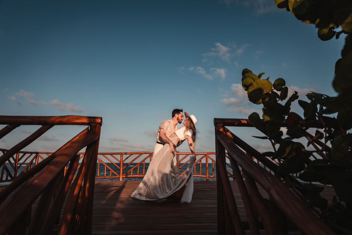 Panoramic view of wooden boardwalk with dramatic sky during sunset.