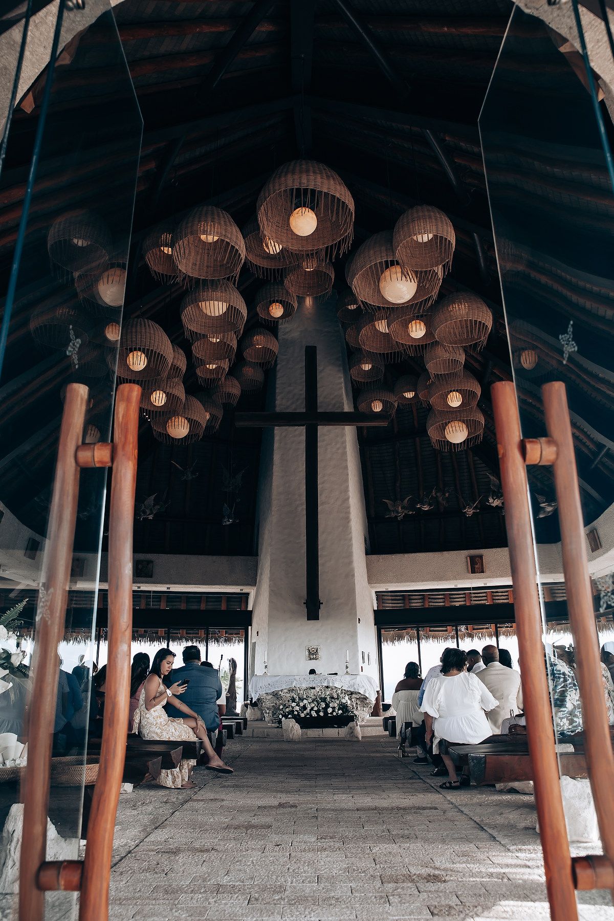 Panoramic view of a covered outdoor space with wooden pillars and hanging round lanterns creating an atmospheric setting.