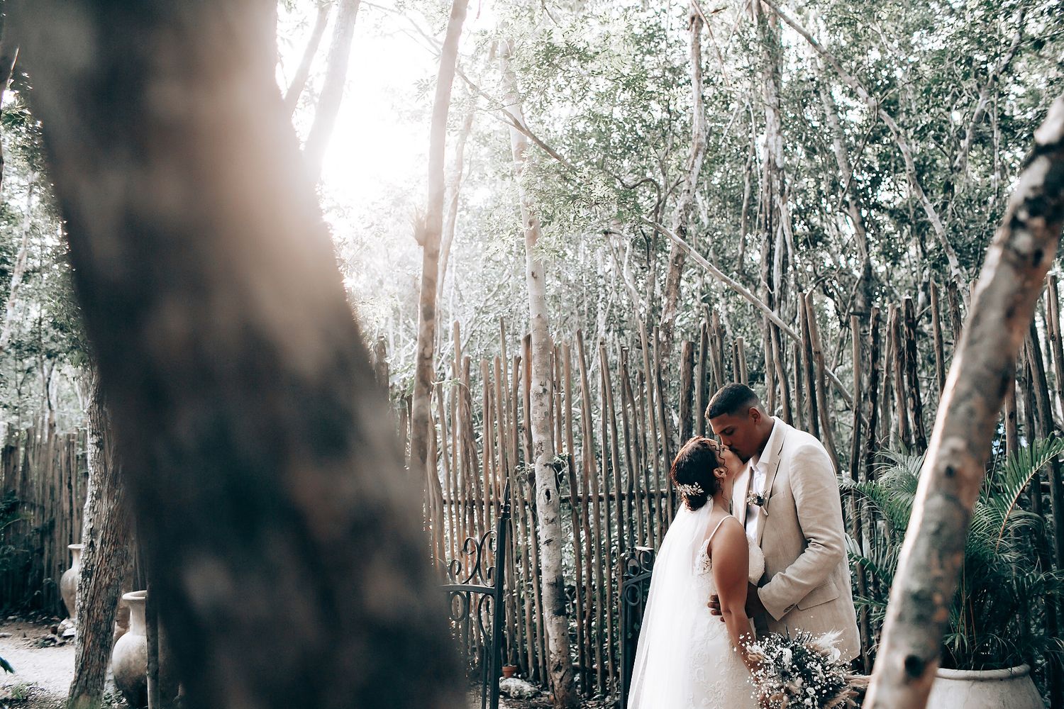 A tender wedding moment photographed in a serene forest setting with soft natural lighting.