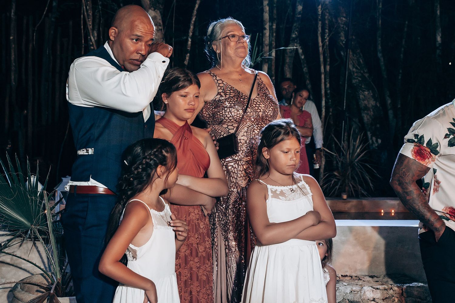 A festive wedding reception moment with guests in formal attire.