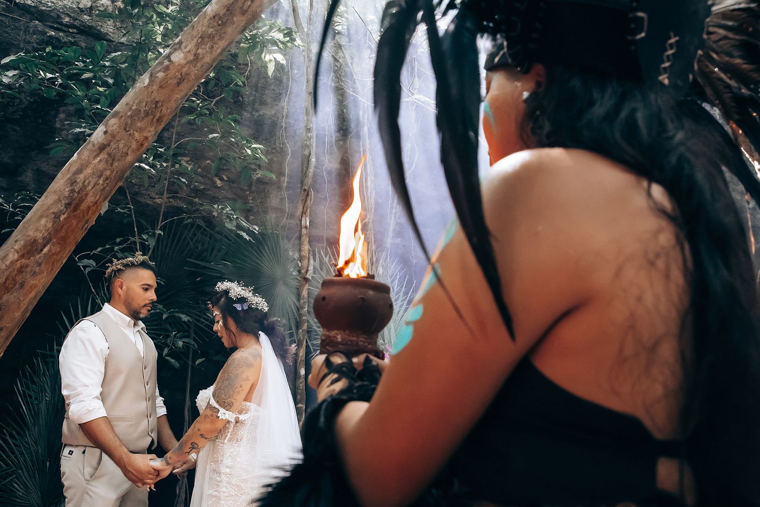Wedding ceremony taking place outdoors with guests gathered around in natural lighting.