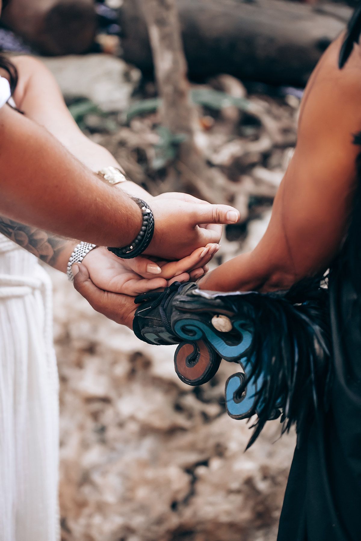 Close-up of hands exchanging rings during an intimate forest wedding ceremony.
