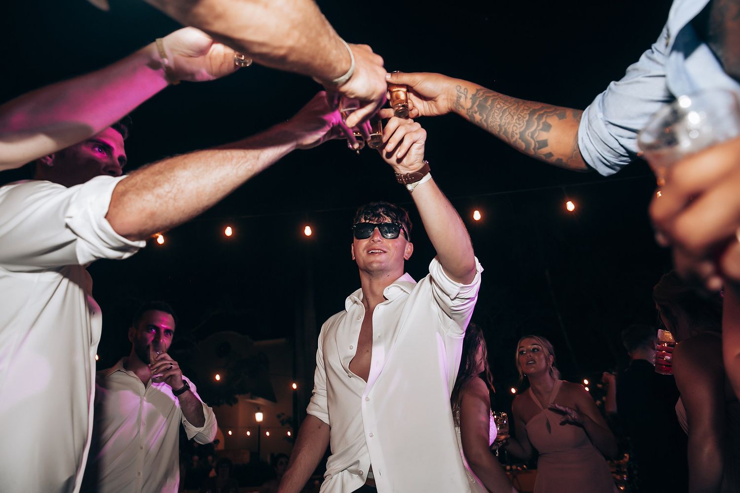 Lively dance party at wedding reception with guests enjoying the celebration.