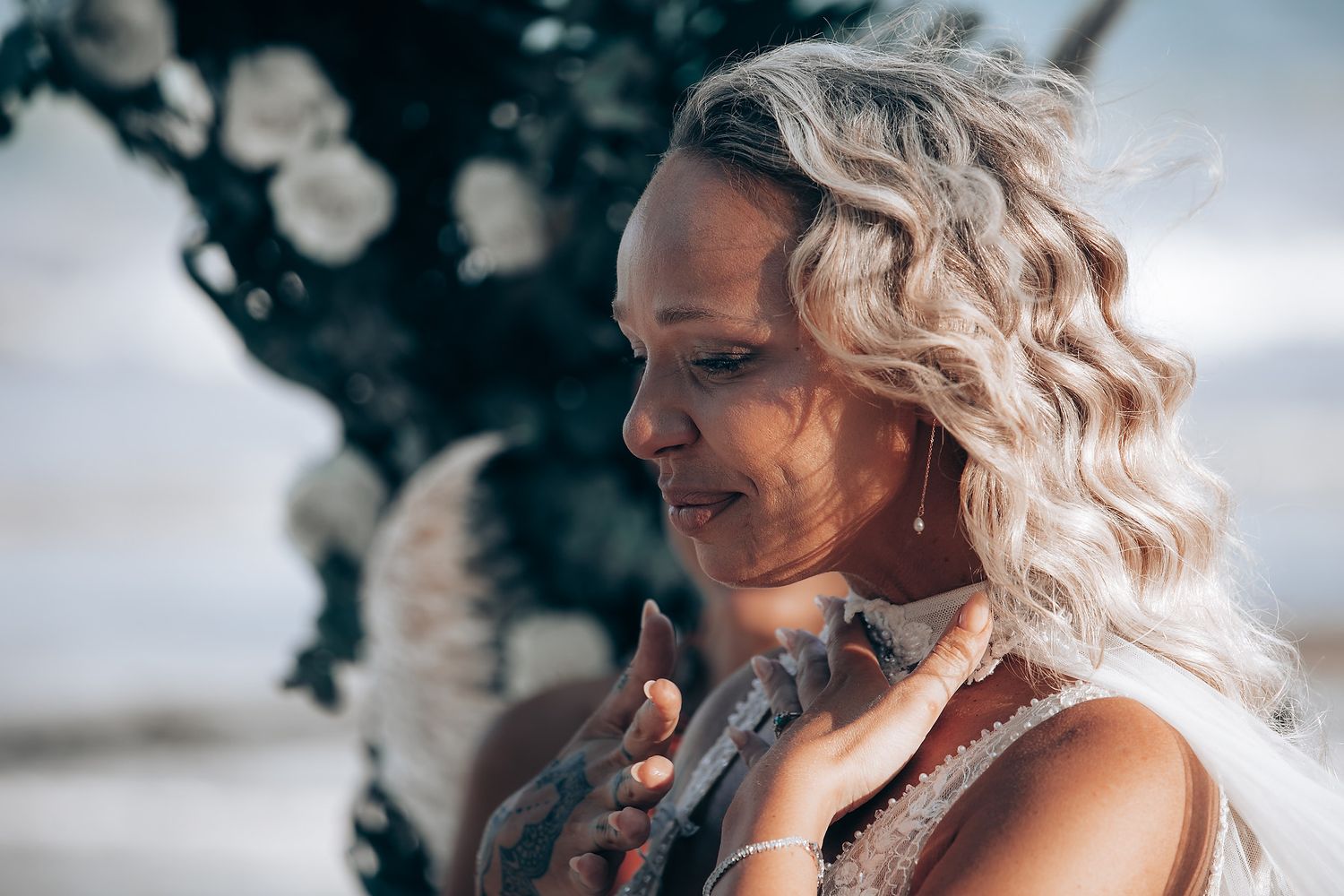 A romantic beach wedding photoshoot with white floral decor and soft lighting at sunset.