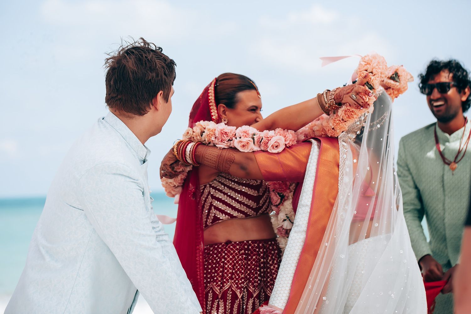 Wedding celebration with guests dancing and enjoying festivities on a beachfront.