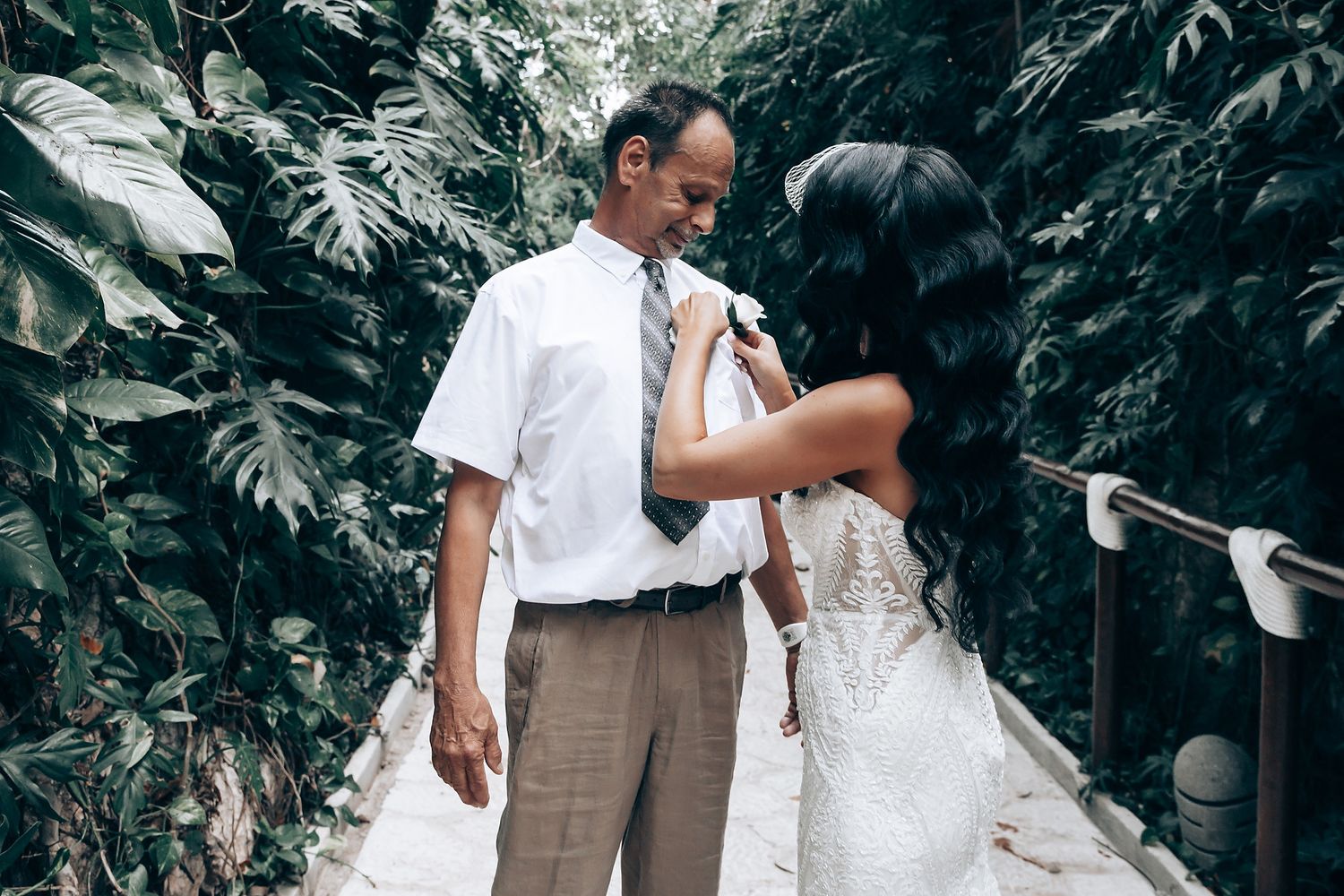 Wedding celebration with guests in white and beige attire outdoors.