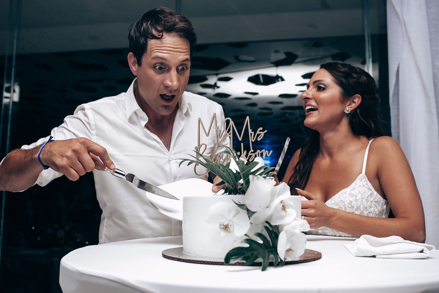 Wedding guests enjoying a celebratory moment at a reception table with white decor.