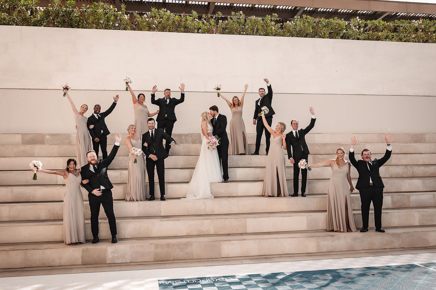 Celebratory group poses of wedding party on stone steps showing progressive joyful moments.