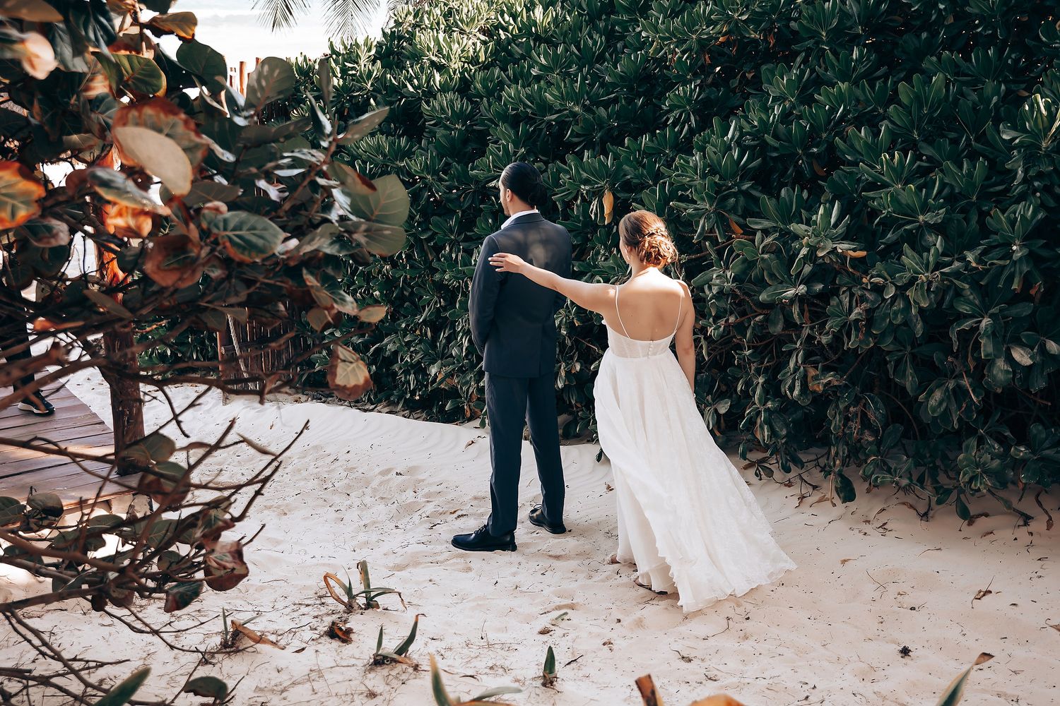 A couple shares an intimate moment during their wedding ceremony on a snowy winter day surrounded by evergreen trees.