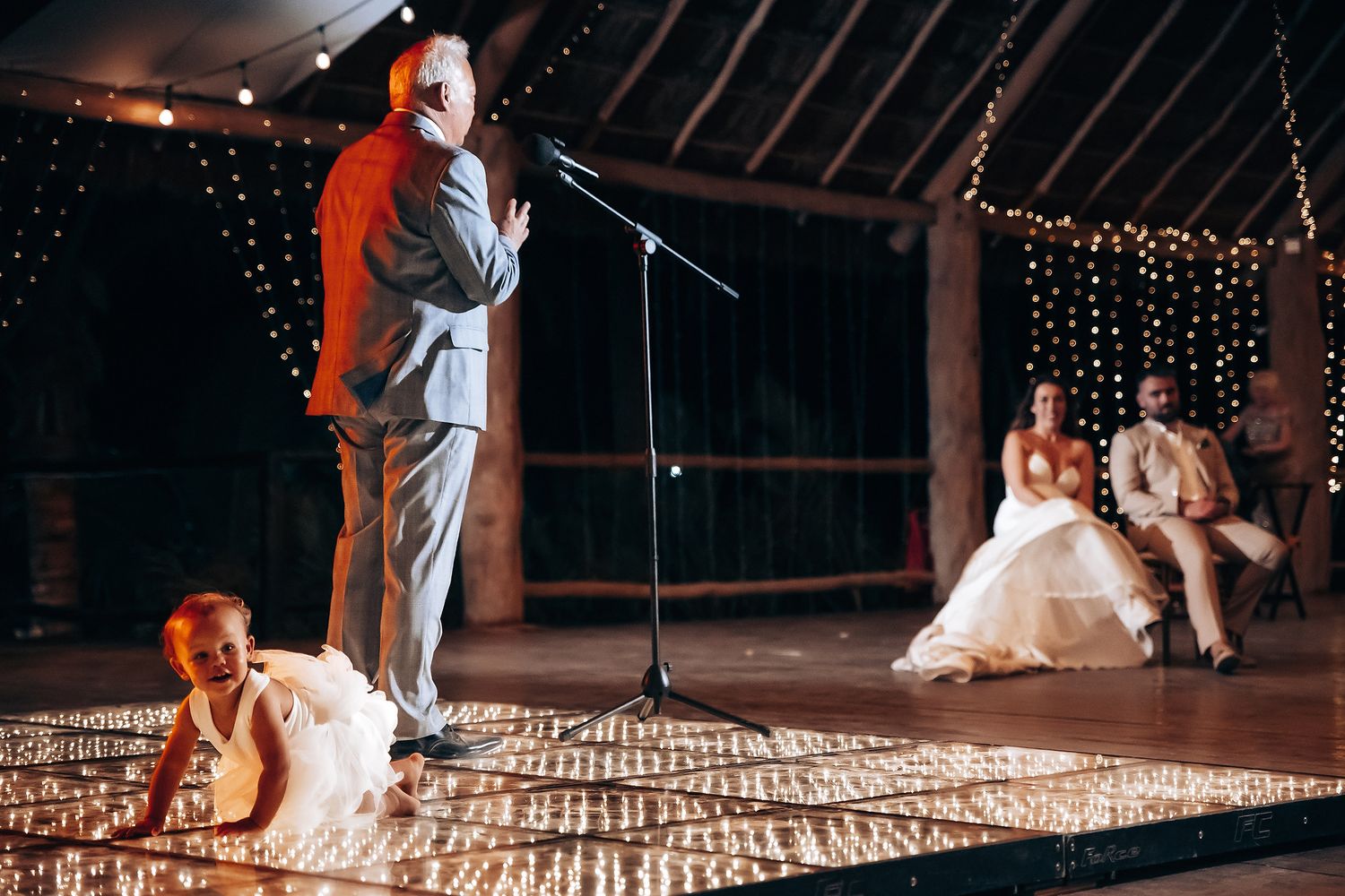 A romantic first dance at a wedding reception with string lights twinkling in the background.