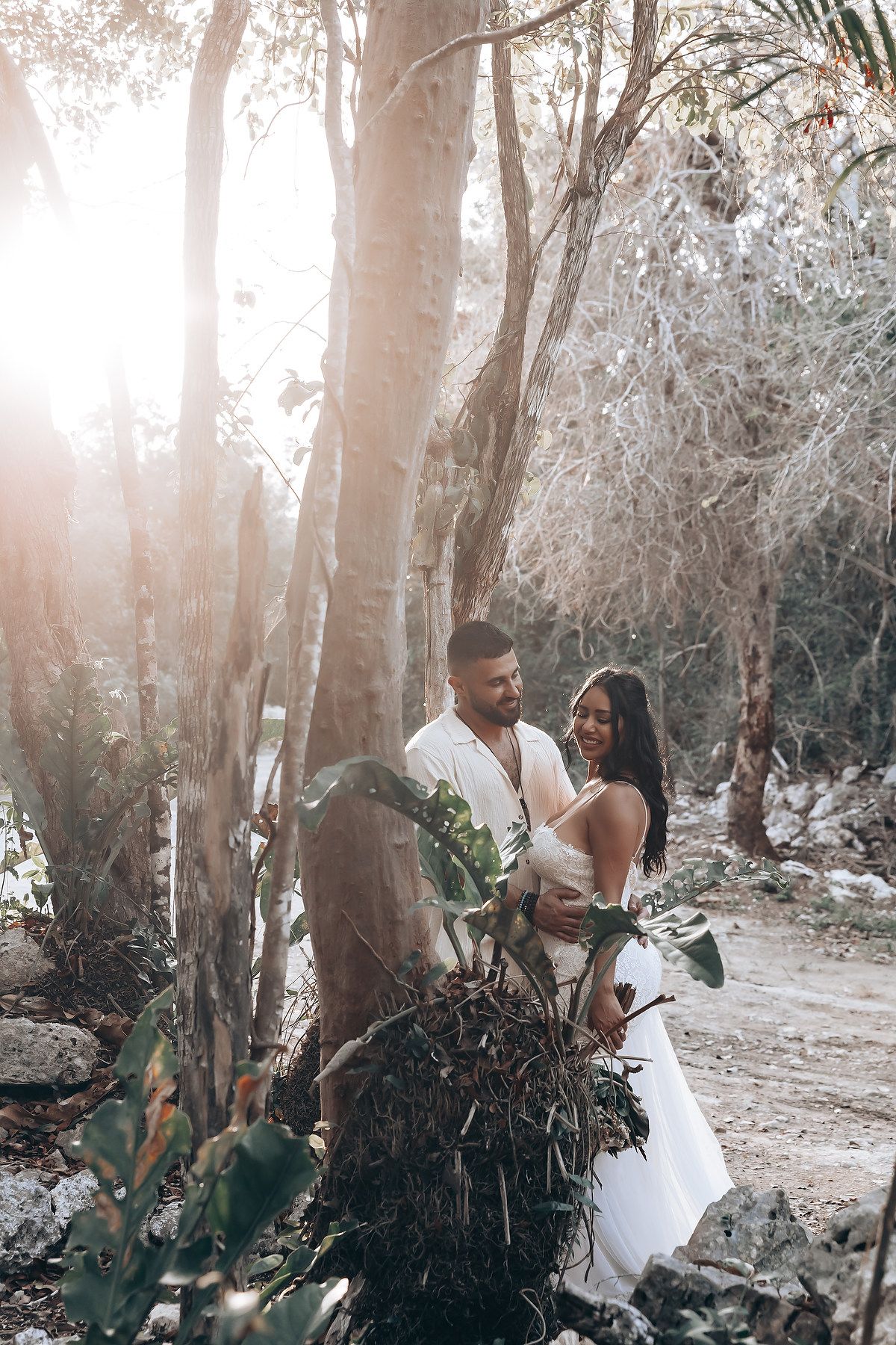 Intimate outdoor photoshoot among tall eucalyptus trees with soft sunlight filtering through the branches.