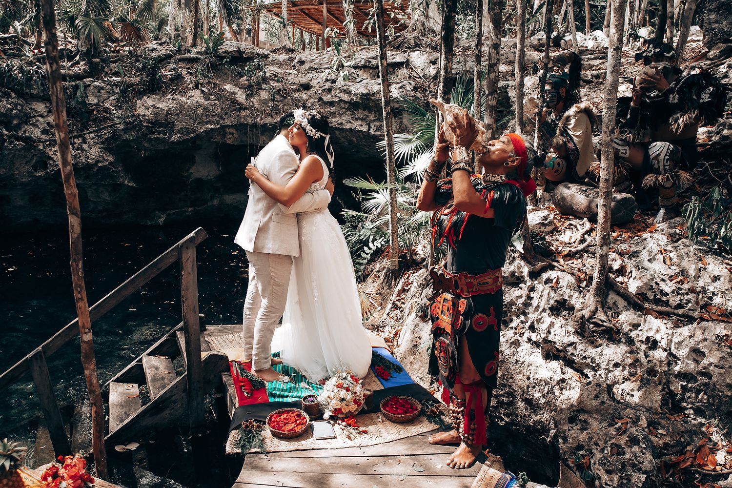 Wedding guests gather in a rustic outdoor setting with natural decor.