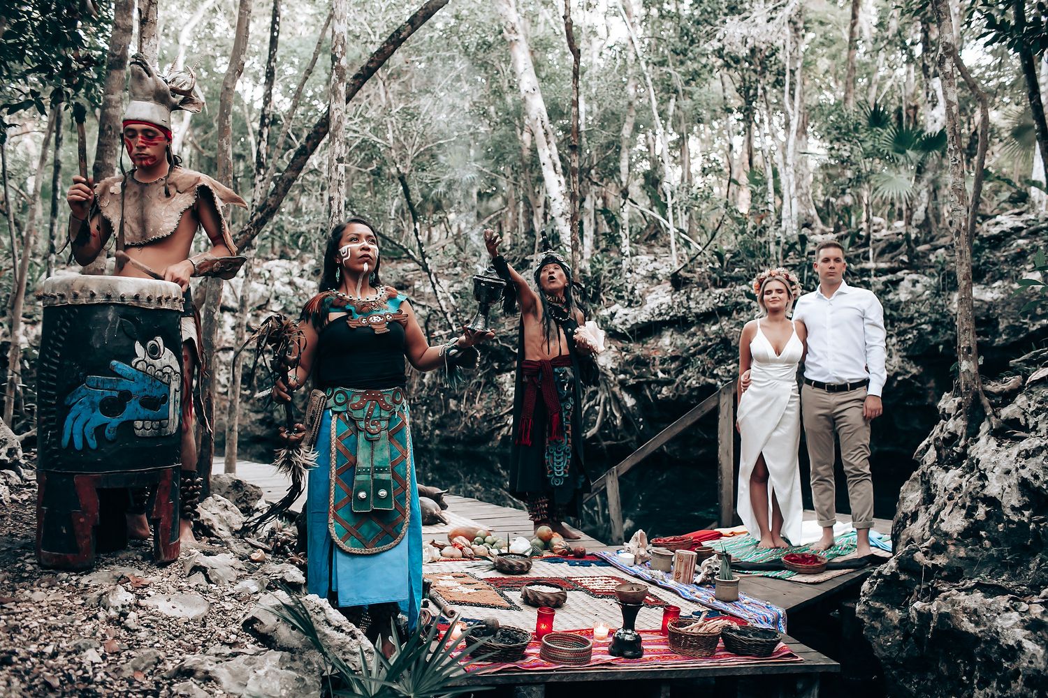 Outdoor wedding celebration in a forest setting with natural decor and ambient lighting.