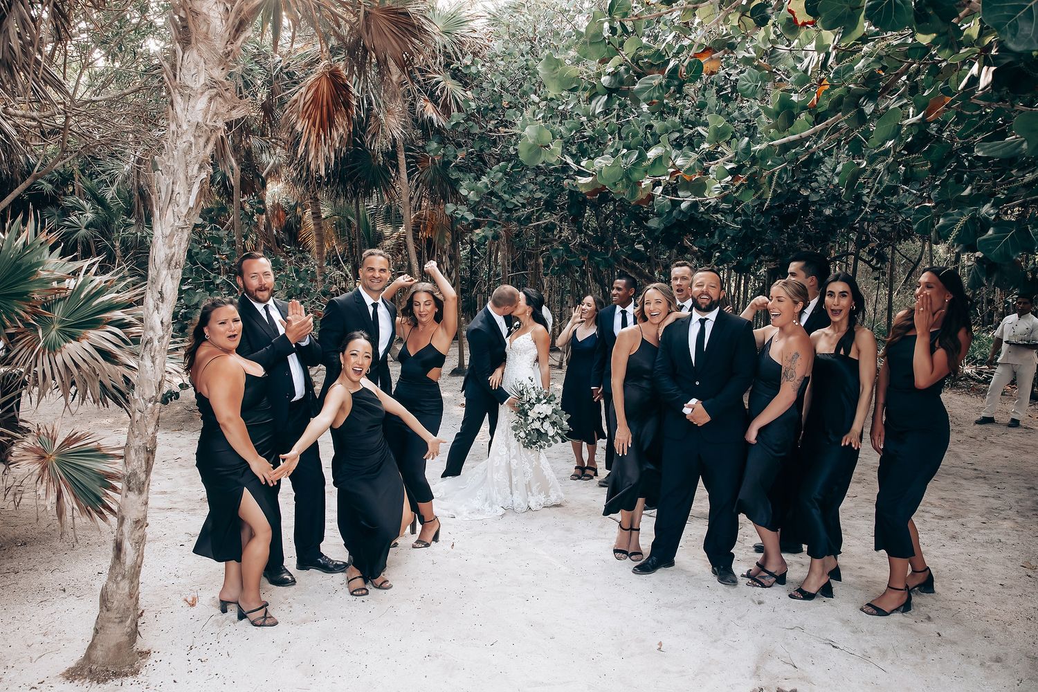 Wedding guests mingling and celebrating in an outdoor tropical garden setting.