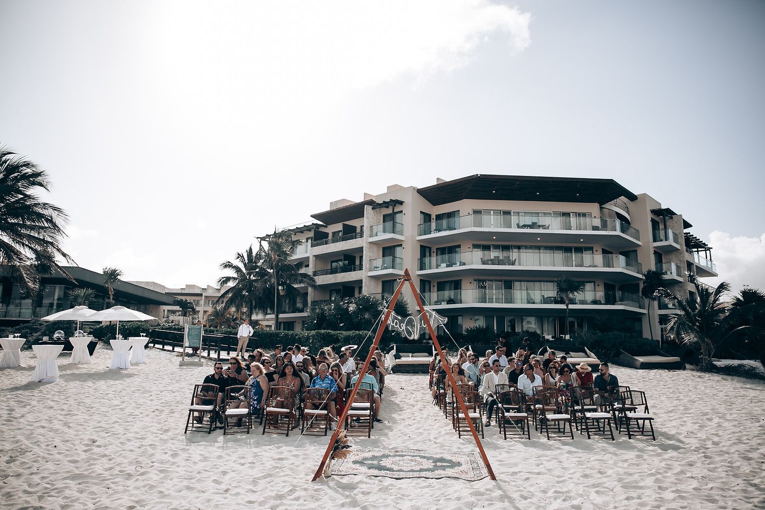 Beachfront resort venue with palm trees and modern architecture along the coastline.