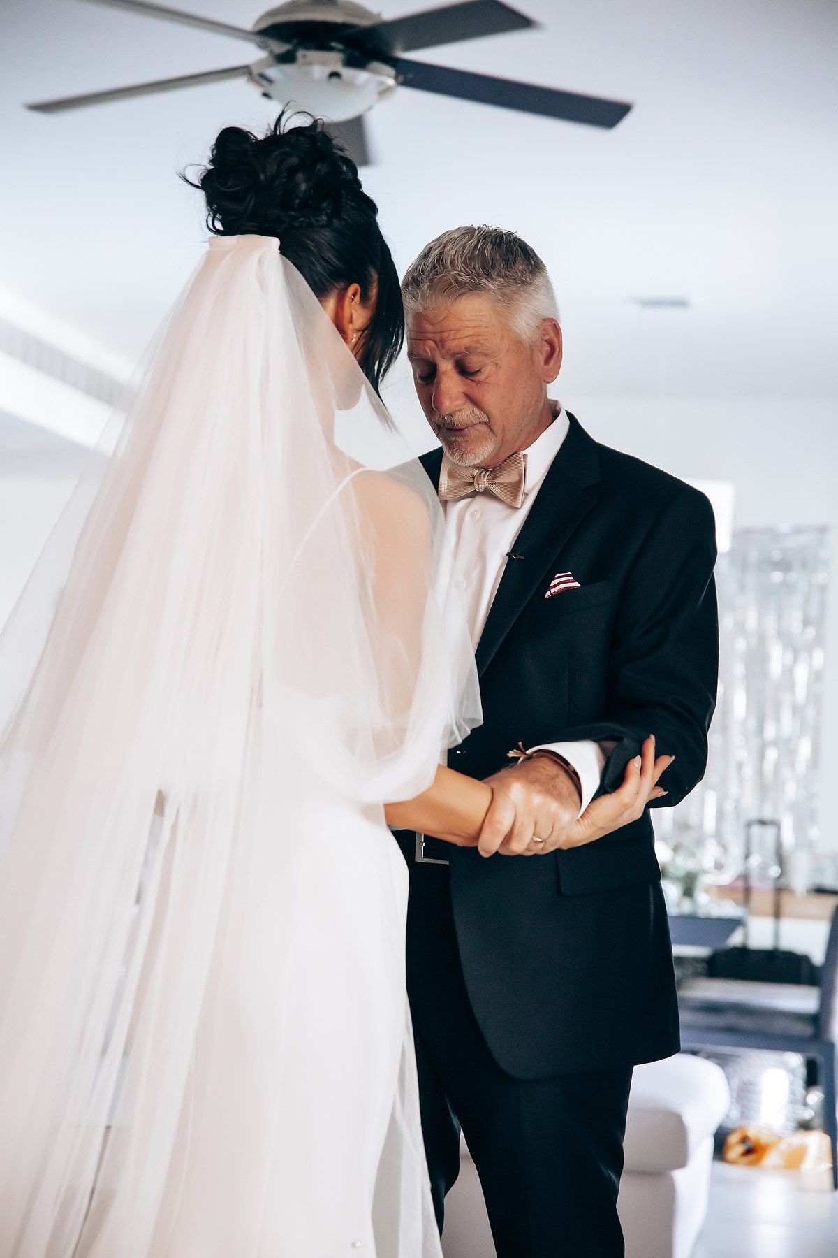 An emotional first look moment at a wedding with someone in a black suit reading a handwritten note.