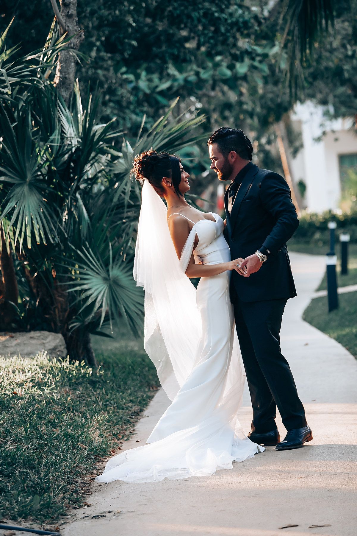 A romantic first look sequence between newlyweds on an outdoor garden pathway.