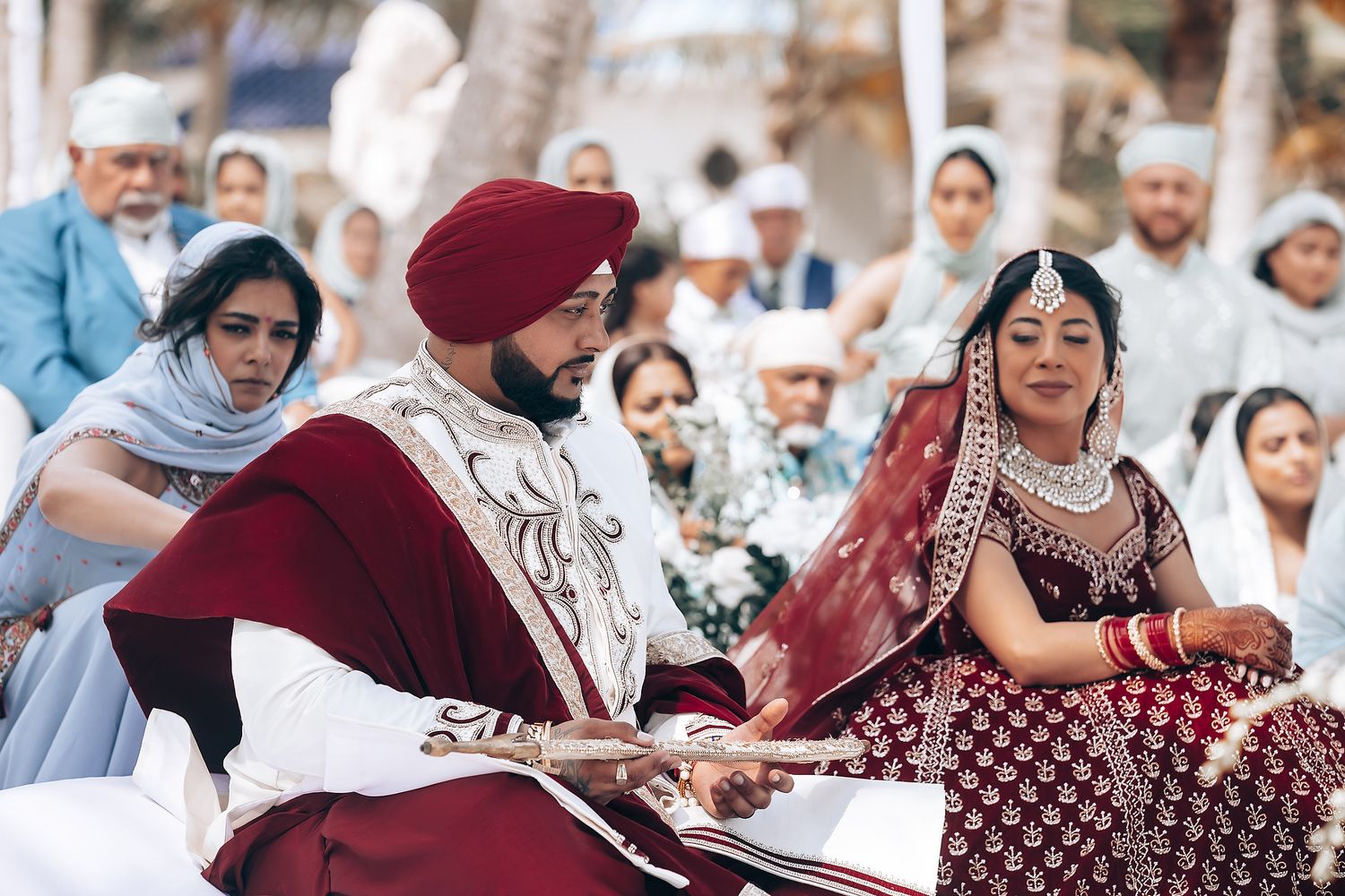Traditional Sikh wedding ceremony guests seated outdoors in formal attire.