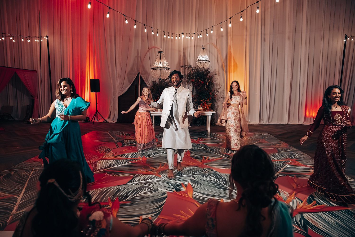 Indoor celebration with string lights and red accent lighting.