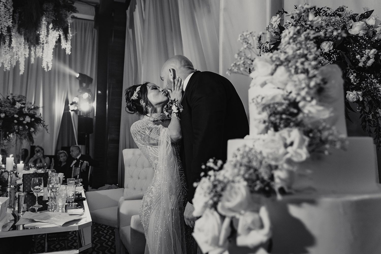 Black and white photo collage of an elegant wedding reception with floral centerpieces and table settings.