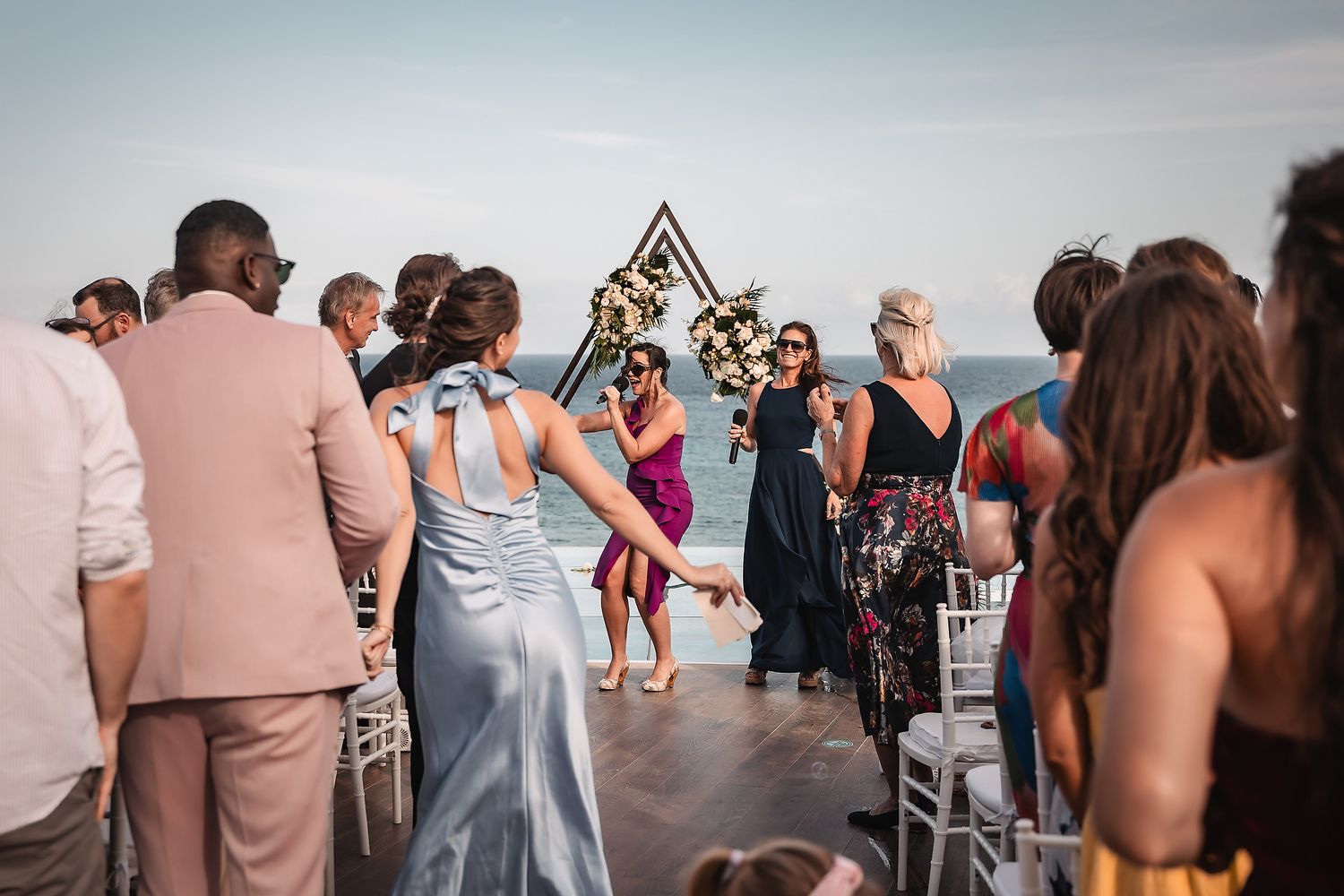 Wedding celebration at a beachside venue with guests enjoying the scenic ocean view.