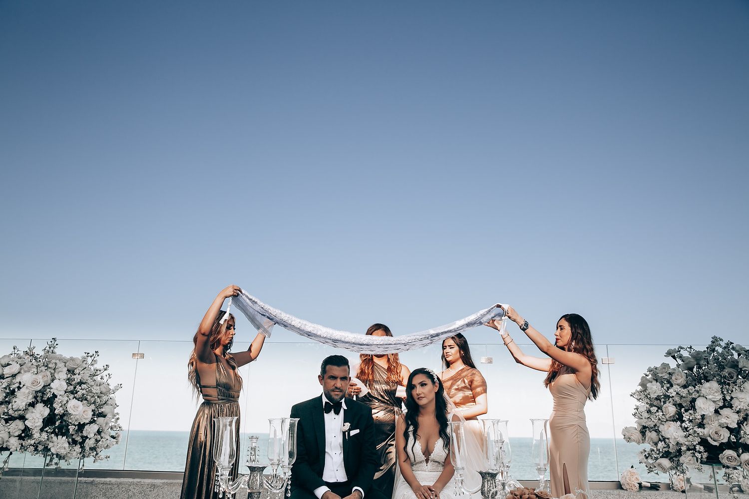 A joyful wedding celebration captured in panoramic shots against a bright blue sky backdrop.