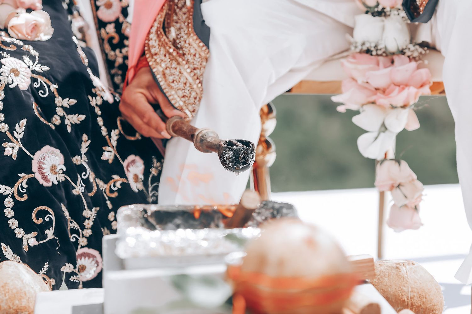 Guests serving traditional Indian food and beverages at an outdoor wedding reception.