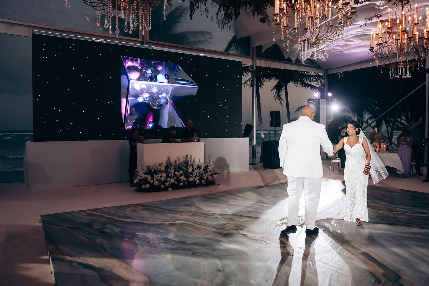 Wedding reception dance floor illuminated by crystal chandeliers creating a magical atmosphere.