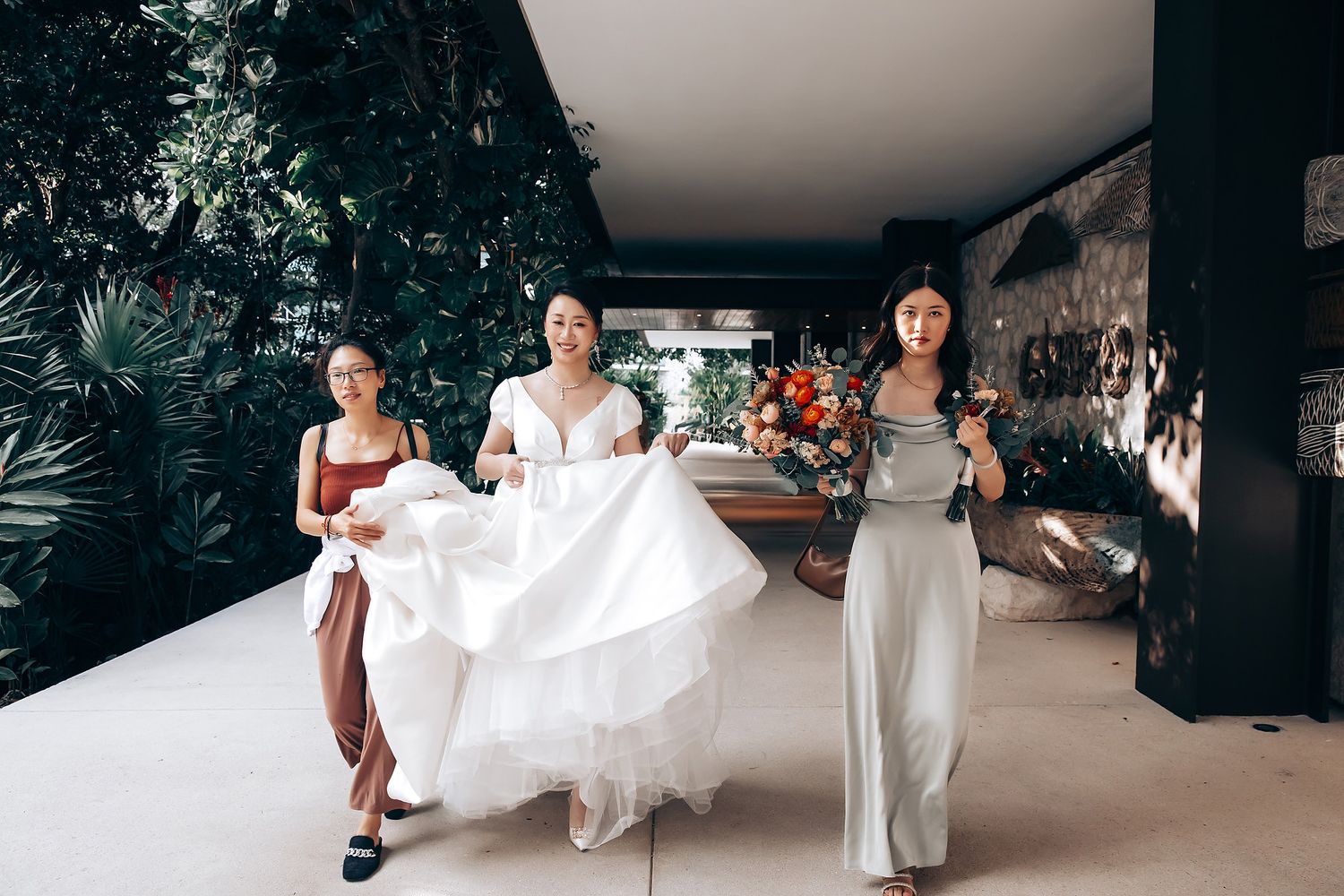 Bride in flowing white gown twirling on outdoor terrace during wedding photoshoot.