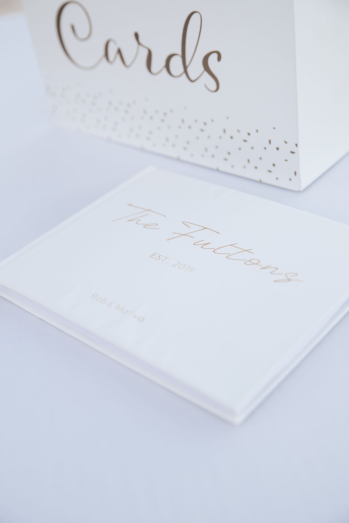 Elegant white wedding stationery with gold foil lettering and delicate details.