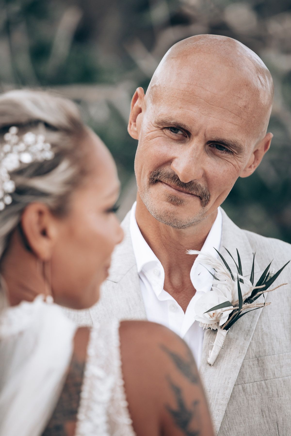 Wedding ceremony moments captured in soft focus with elegant white and floral details.