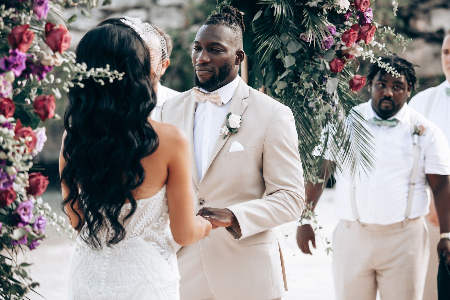 Wedding celebration with floral decorations and guests in formal attire at an outdoor venue.