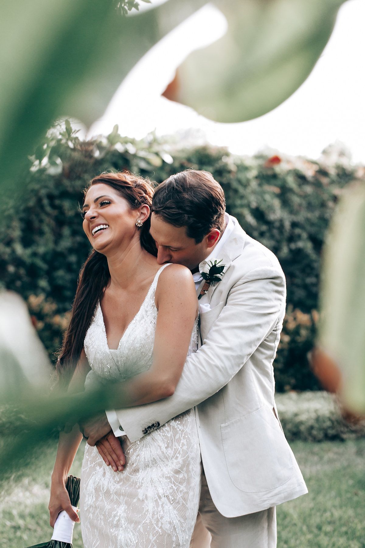 Candid moment between newlyweds in a lush garden setting.