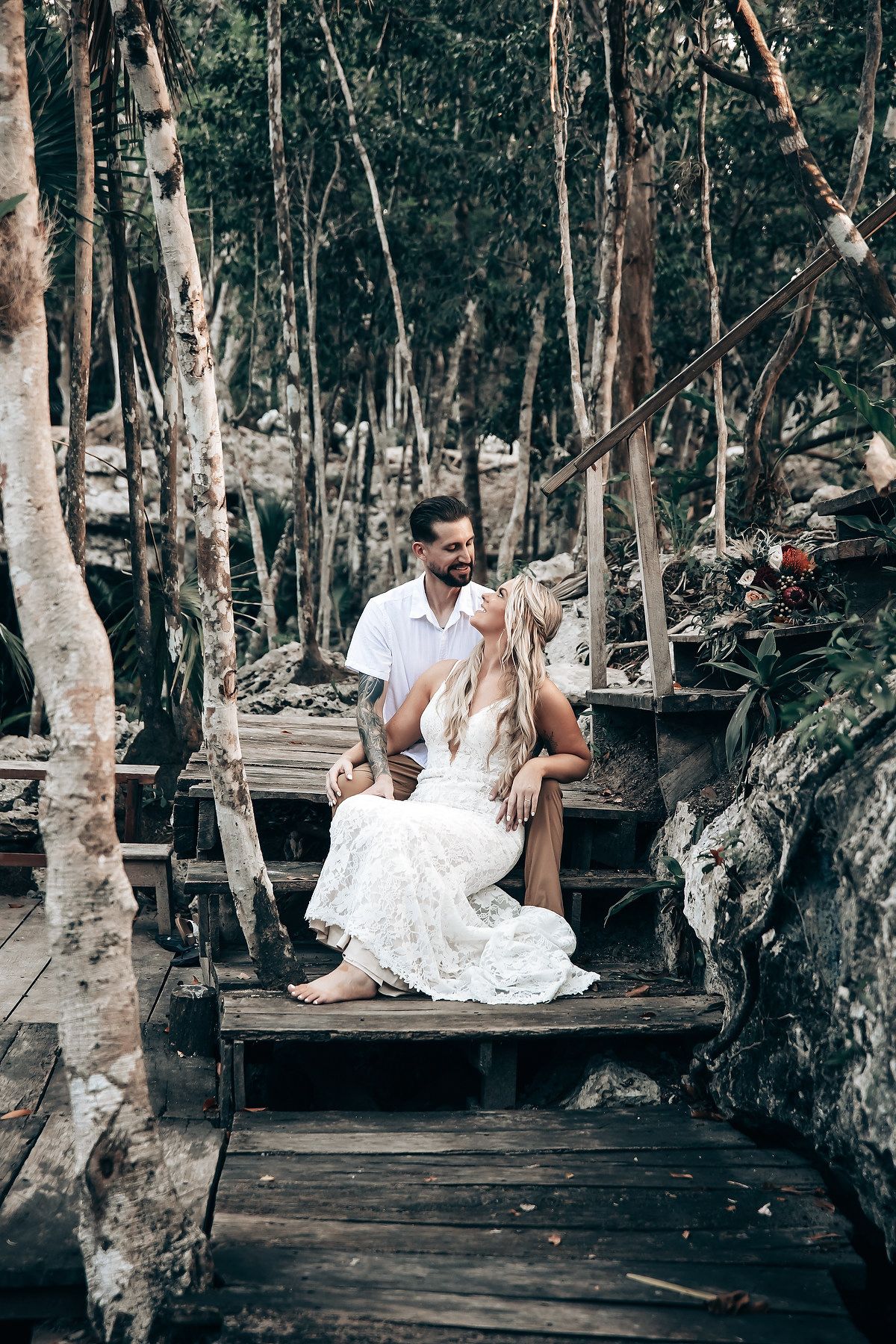 Rustic wooden platform surrounded by trees creates intimate ceremony setting in nature.