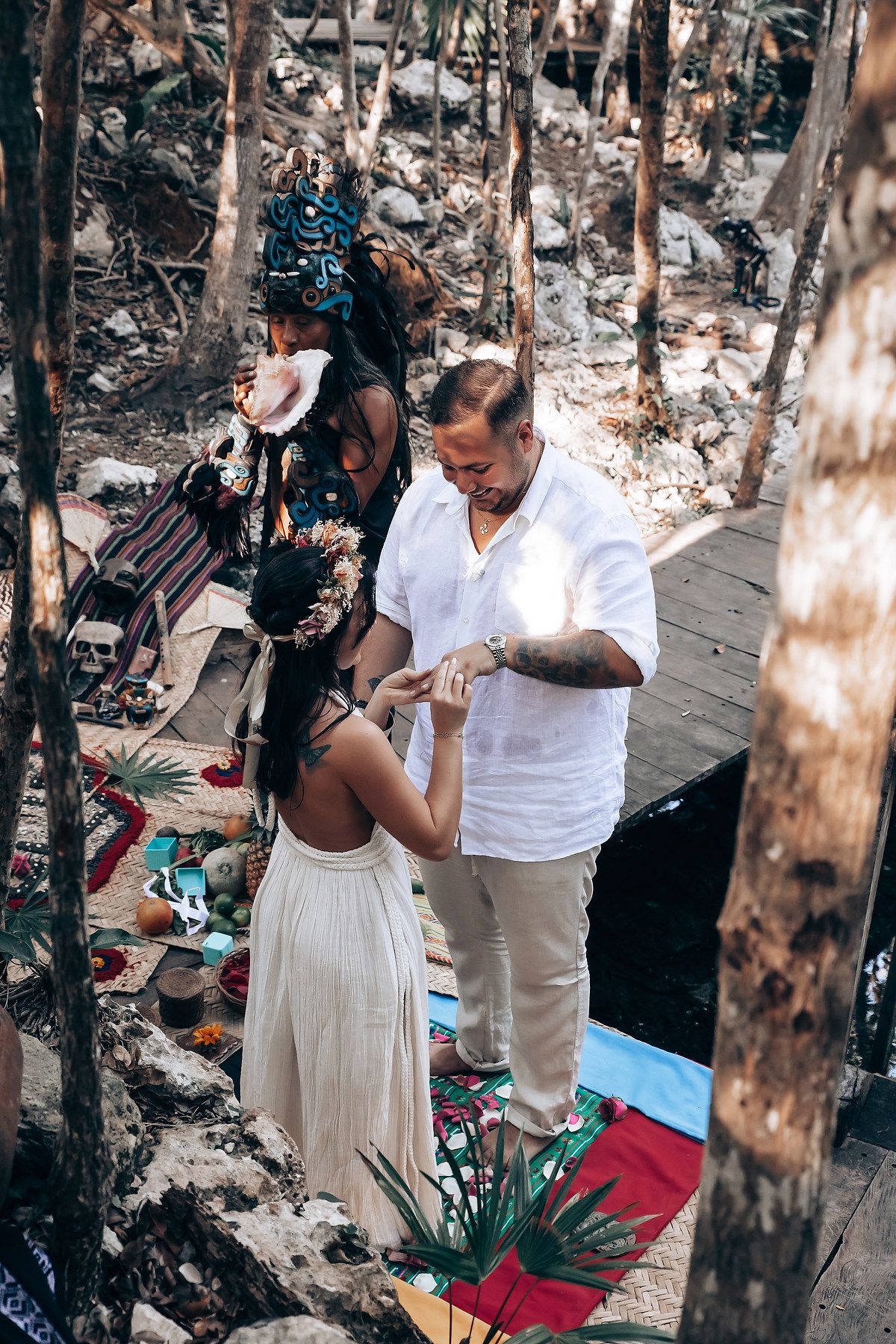 A sacred ritual takes place on a wooden deck surrounded by lush forest and natural elements.