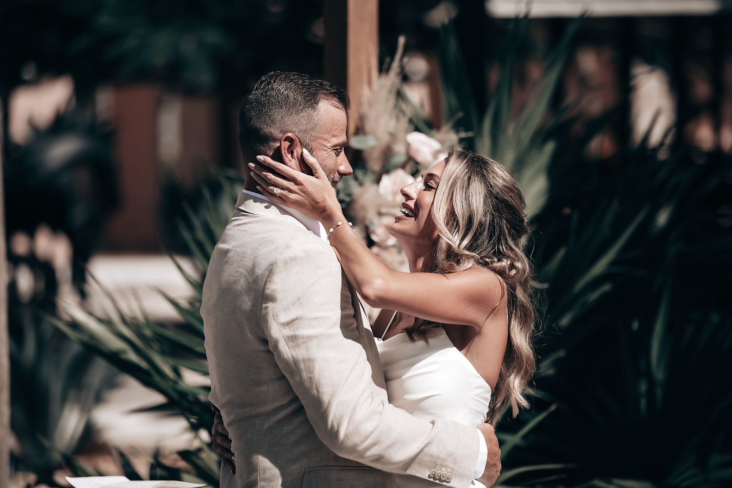 A couple embracing and kissing at what appears to be an outdoor wedding or event.