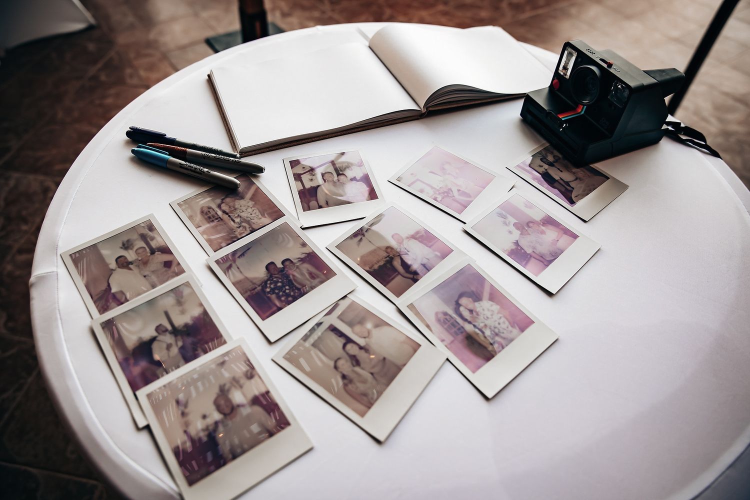 A table has various polaroid photos and other items on it.
