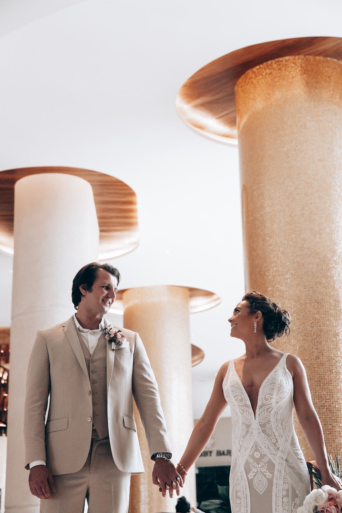 Modern wedding venue interior with architectural columns and soft lighting creating an elegant atmosphere.