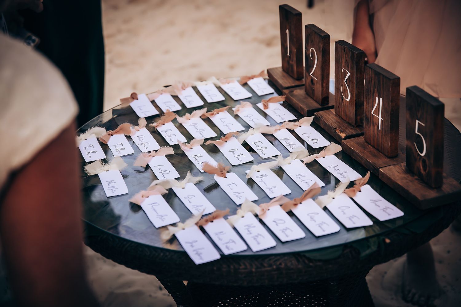 Wedding place cards arranged neatly on dark wooden surface.