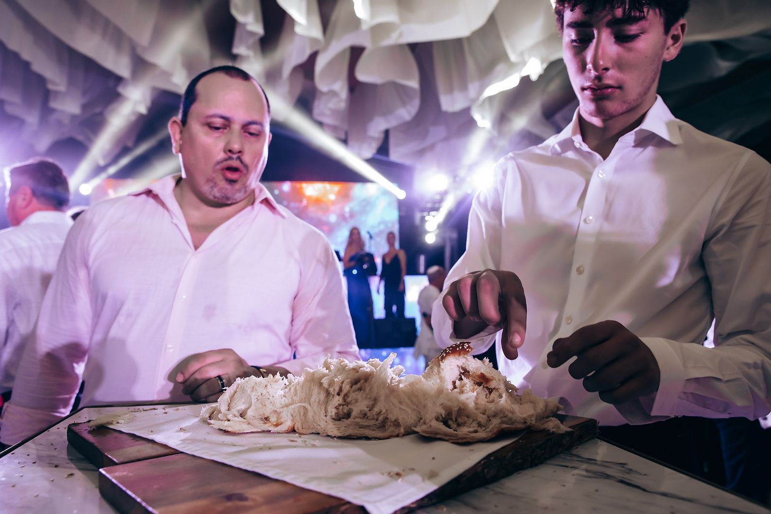 Chefs preparing fresh bread dough at an elegant indoor event.