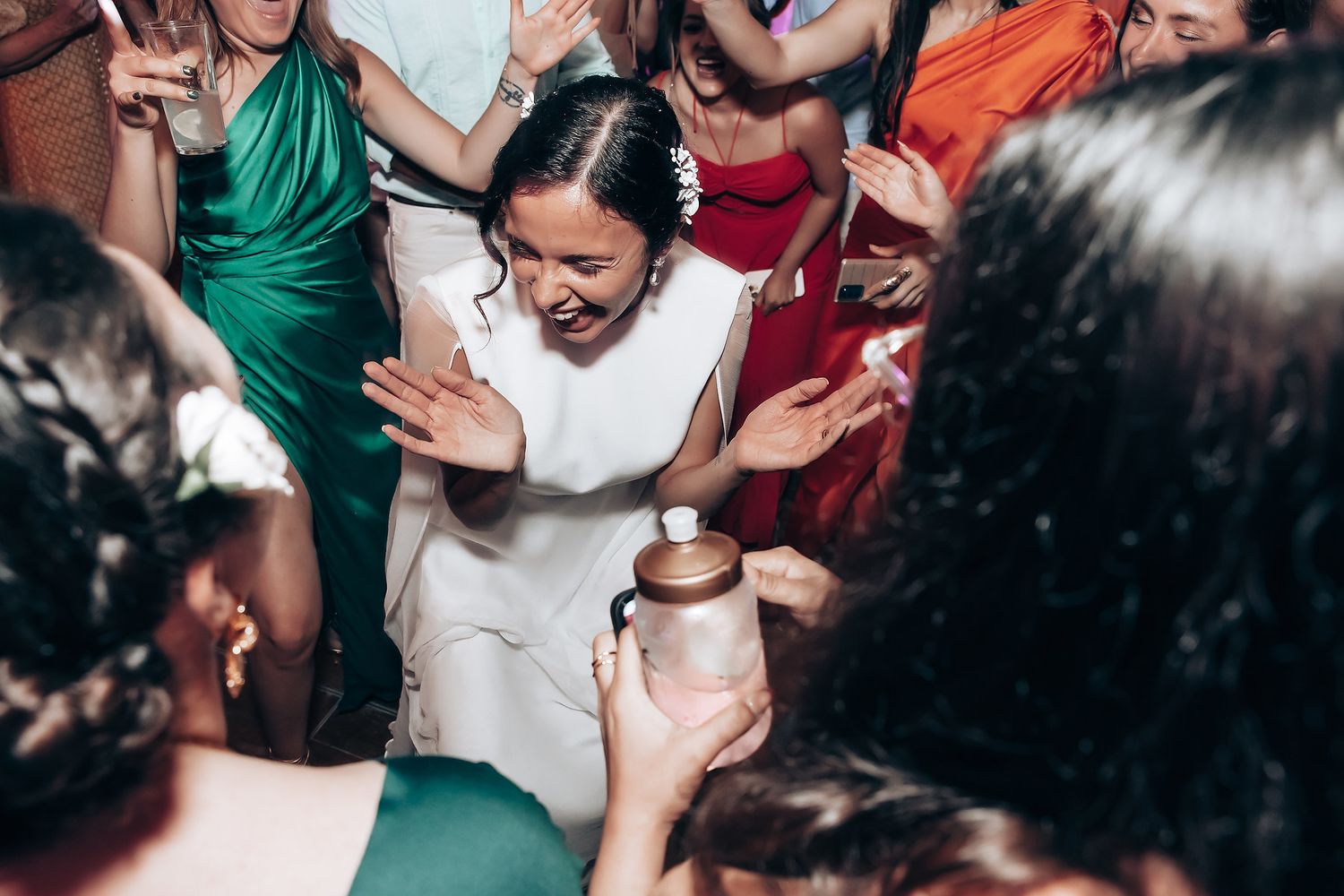 Wedding celebration showing guests dancing and celebrating in a lively party atmosphere.