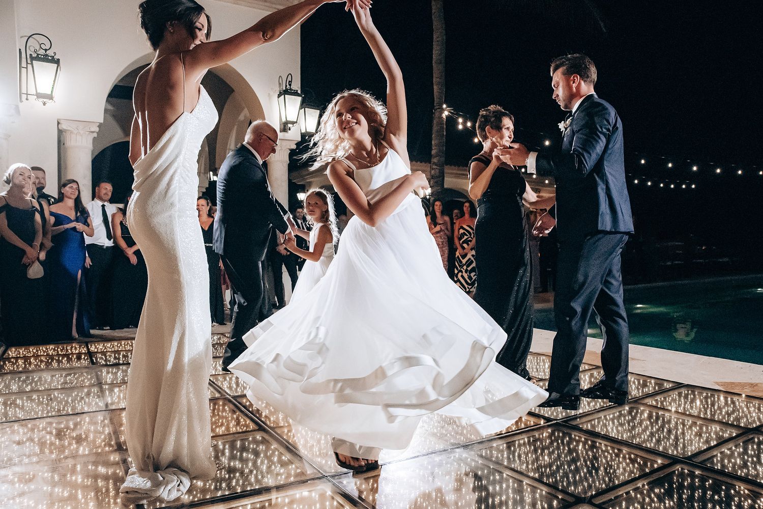 A series of wedding celebration photos showing dancing and festivities at an elegant indoor reception venue.