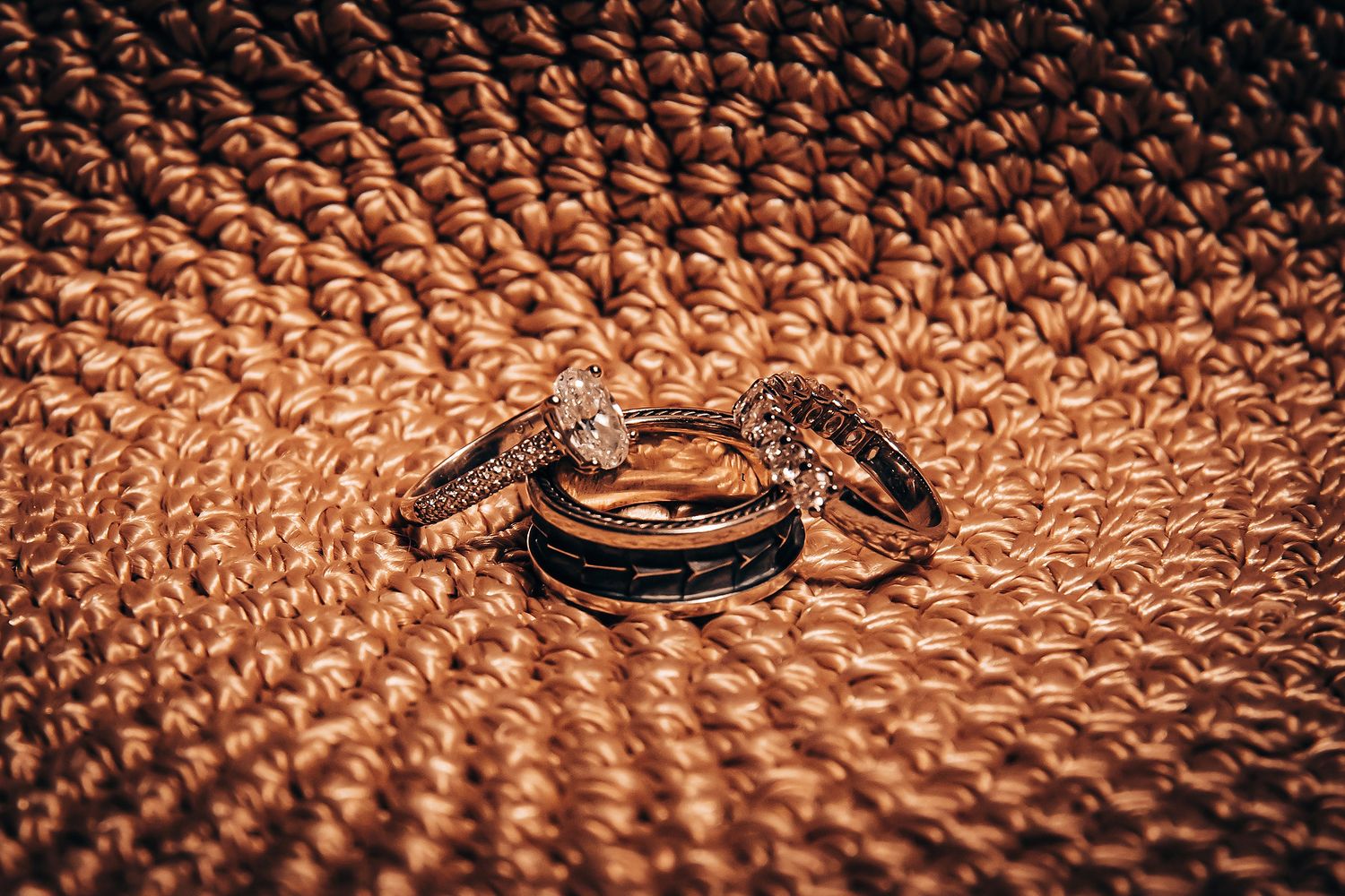 Close-up macro photography of copper or rose gold metallic surface with repeating circular pattern and dramatic lighting.