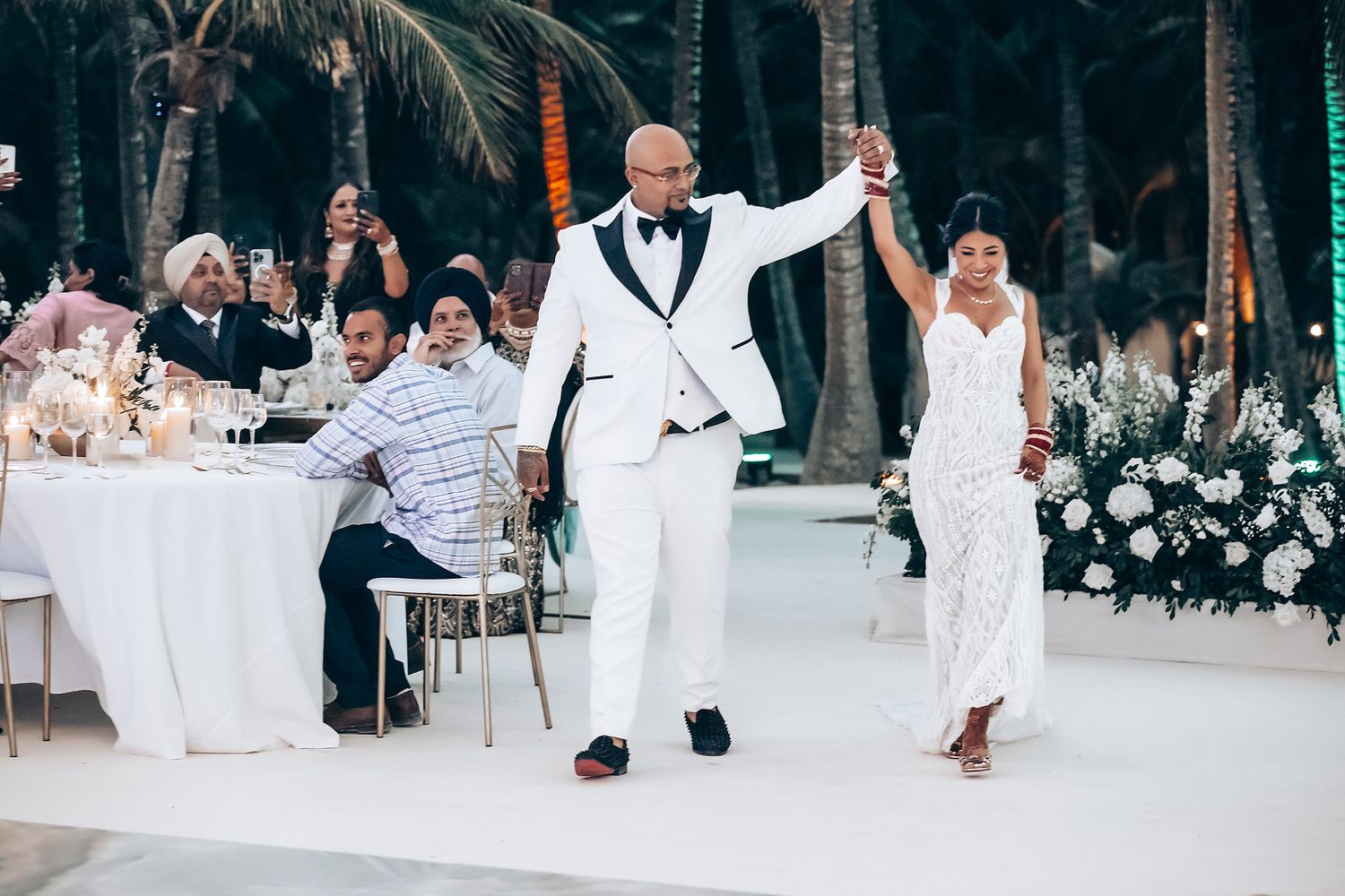 Wedding guests celebrating and dancing at an outdoor beach reception.
