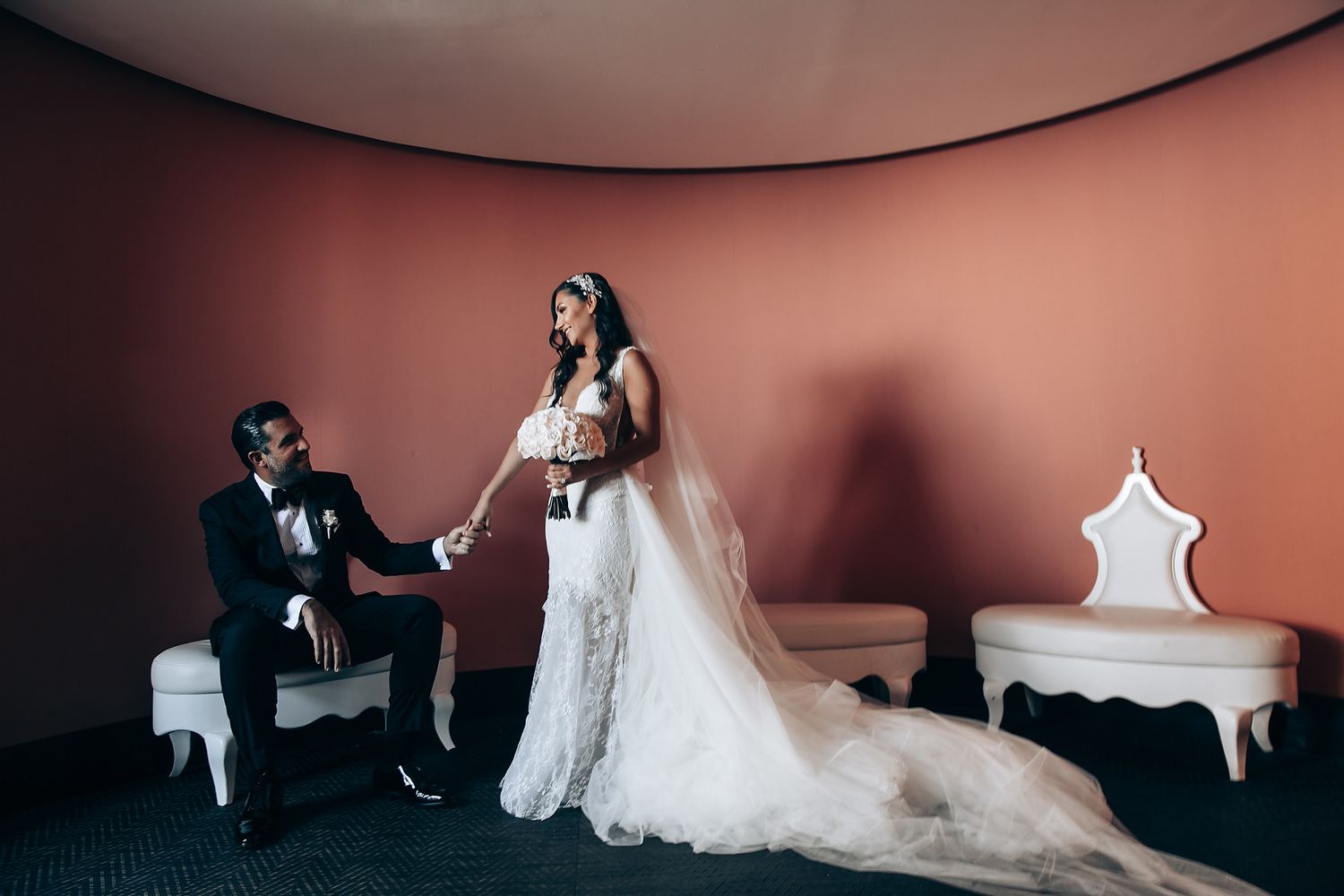 Romantic wedding reception setup with soft pink lighting and elegant decor.